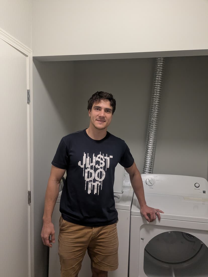 The Founder proudly standing next to newly installed laundry equipment